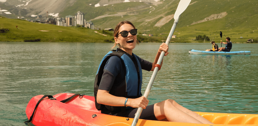 activités en famille: femme souriante sur un kayak à Tignes