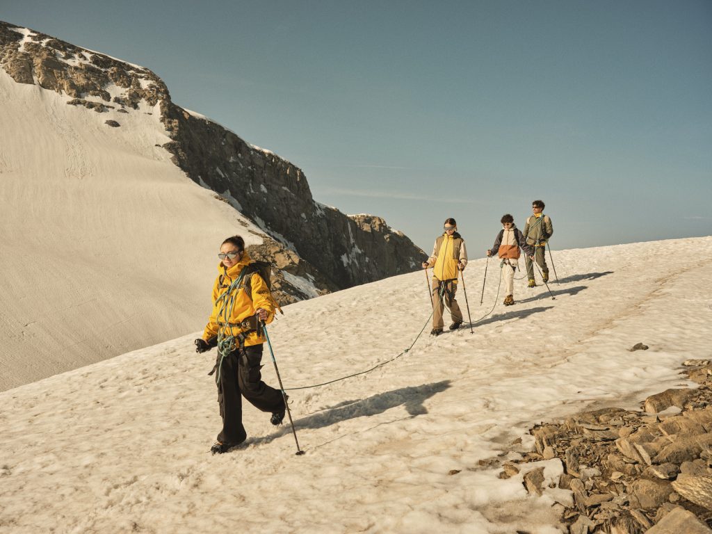 quatre personnes en tenue de randonée entrain de marcher sur la neige