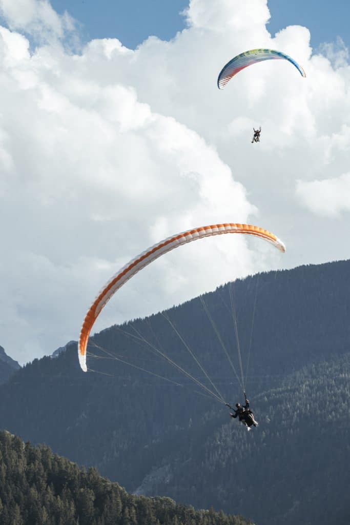 deux personnes entrain de faire du parapente dans la montagne